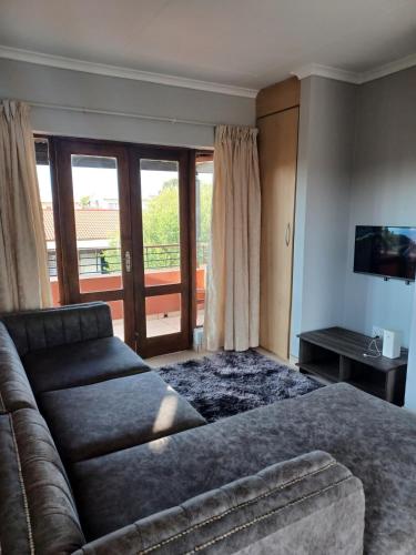 a living room with a couch and a television at Sanctuary at Waterfall in Midrand
