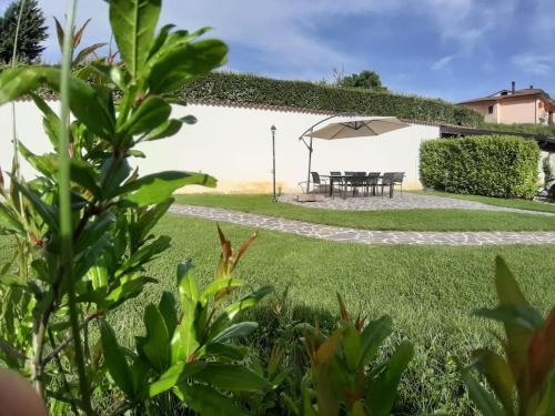 a garden with a table and an umbrella at Casa Menestra in Scoppito