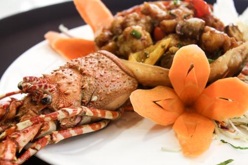 a plate of food with a sandwich and other foods at Hotel Southern Comfort in Chennai