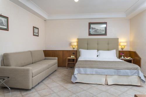 a hotel room with a bed and a couch at Montespina Park Hotel in Naples