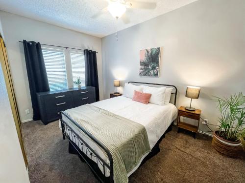 a bedroom with a bed and two lamps and a plant at Cozy and Quiet, with Easy Access & Private Garage in Corpus Christi