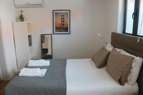 a bedroom with a bed with two towels on it at 9 min Metro to Downtown -Remote working - Free Parking in Porto