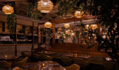 a restaurant with tables and chairs and chandeliers at Godfrey Hotel Chicago in Chicago