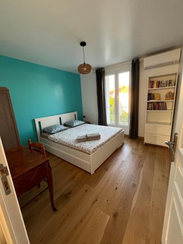 une chambre avec un lit et un parquet dans l'établissement Villa la Désirée ,haut de la villa, entièrement rénovée, 4 étoiles, climatisé, parking privé et 120m2 de jardin, à Antibes