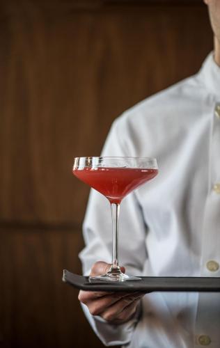 a man holding a martini glass on a tray at Godfrey Hotel Chicago in Chicago