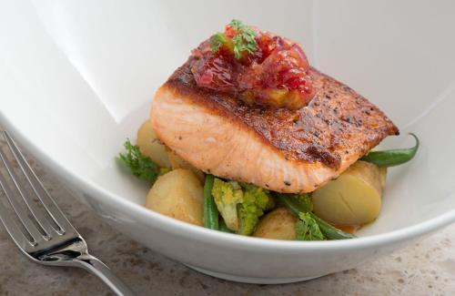 a bowl of food with a piece of fish and potatoes at Godfrey Hotel Chicago in Chicago