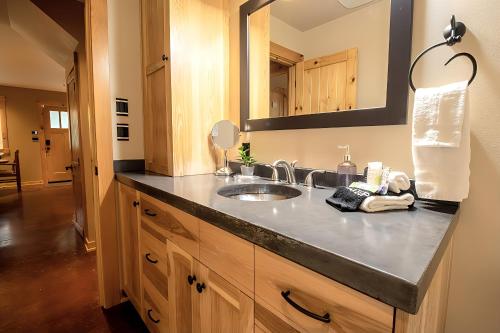 eine Badezimmerablage mit Waschbecken und Spiegel in der Unterkunft 2 Kings, Fire Pit, Gameroom, EV charger, Dogs OK! in Glacier