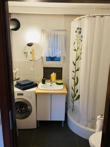 a bathroom with a sink and a shower curtain at Noclegi u Justyny in Łagów
