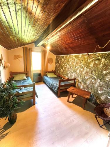 un salon avec deux lits et une table dans l'établissement Maison de vacances familiale, à Quillan