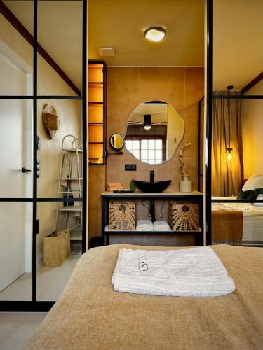 a bathroom with a bed and a sink and a mirror at YOSO Tenerife in Acantilado de los Gigantes