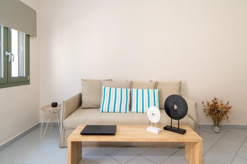 a living room with a couch with a laptop on a table at Blue View Villas in Stalida
