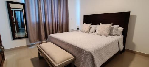 Un dormitorio con una cama grande y un espejo. en Margarita 4toB, en Marilópez