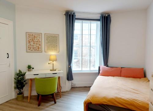 a bedroom with a bed and a desk and a window at Spacious Victorian Apartment in Edinburgh City in Edinburgh