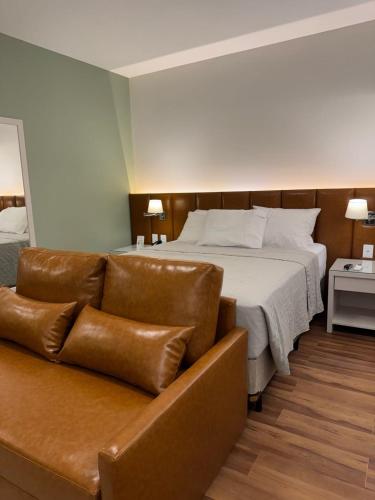 a hotel room with a bed and a couch at ArqSuites Berrini WTC SP - Suíte privada dentro do Hotel Wyndham in Sao Paulo