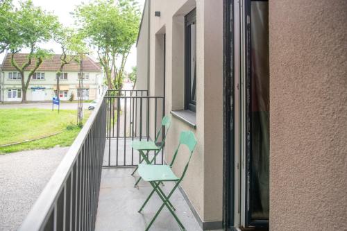 two chairs sitting on the balcony of a building at Velora apartments in Subotica