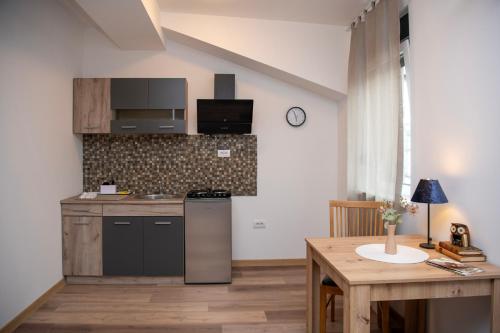 a kitchen with a stove and a table in a room at Velora apartments in Subotica