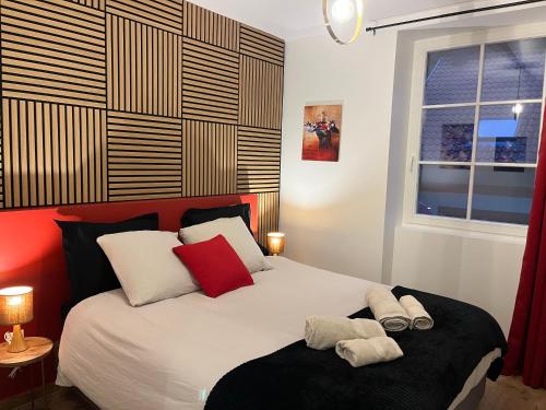 Un dormitorio con una cama con almohadas rojas y blancas. en Le repaire des Supers Héros, en Thannenkirch