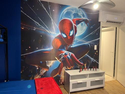 une chambre avec une fresque murale représentant un homme d'araignée dans l'établissement Le repaire des Supers Héros, à Thannenkirch
