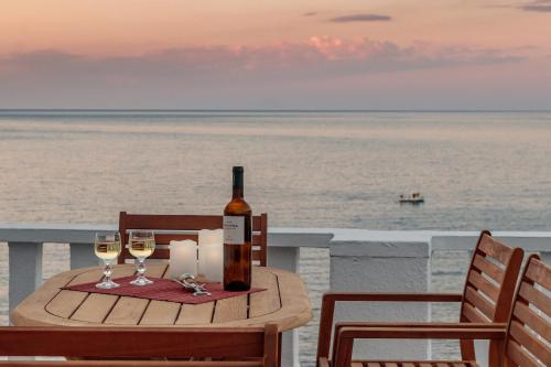 a table with a bottle of wine and two glasses at Villa Skopelita in Skopelos Town