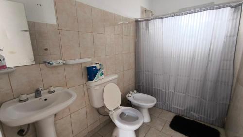 une salle de bain avec toilettes et lavabo dans l'établissement Casa con cochera y patio cerrado, Ruka del Rio, à Choele Choel