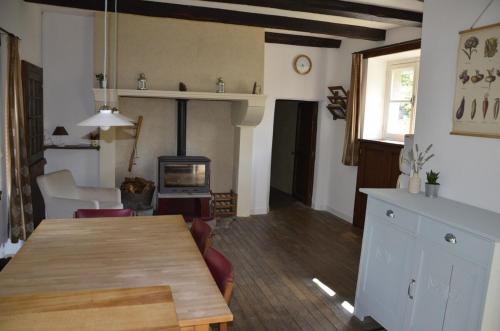 - un salon avec une table en bois et une cheminée dans l'établissement Renovated water mill next to the river Tardes, à Saint-Sylvain-Bellegarde