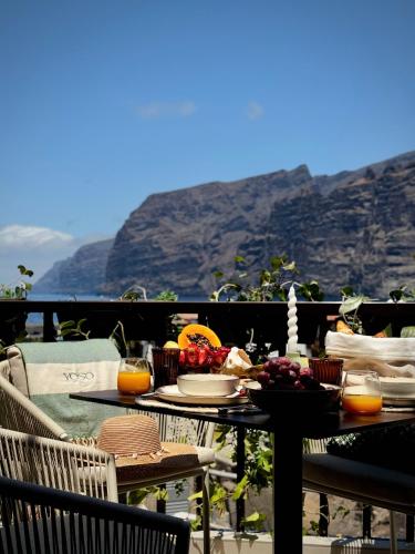 a table with food and fruit on top of a balcony at YOSO Tenerife in Acantilado de los Gigantes