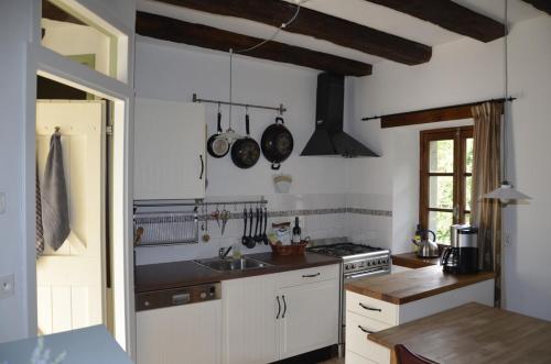 une cuisine avec un évier et une cuisinière dans l'établissement Renovated water mill next to the river Tardes, à Saint-Sylvain-Bellegarde