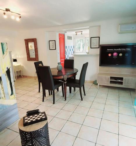 une salle à manger avec une table, des chaises et une télévision dans l'établissement Suite and garden BLUE EDEN, plages de Saint-Raphaël Côte d Azur, à Saint-Raphaël