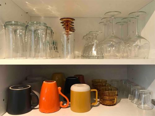 a shelf filled with glass jars and cups at Taminimaison in Laval