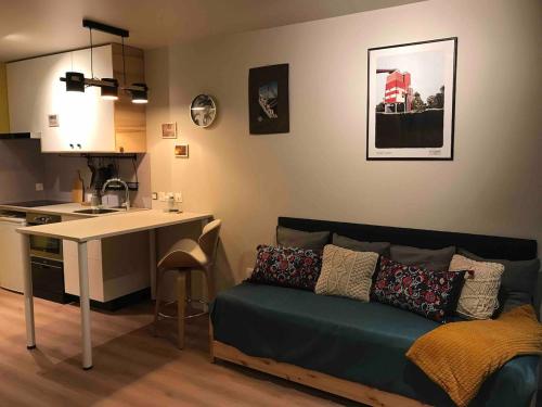 a living room with a couch next to a kitchen at Taminimaison in Laval