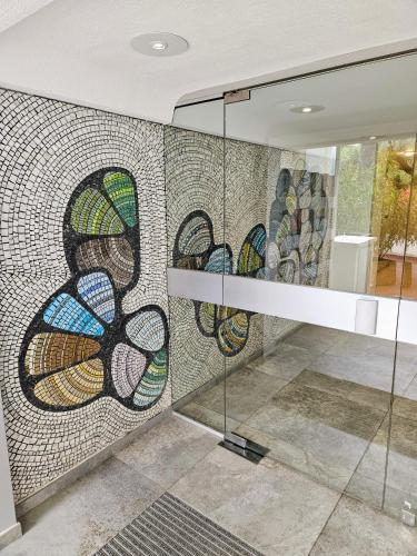 un mur en mosaïque dans une pièce avec un escalier dans l'établissement Appart 2 pièces, Juan les Pins, plage 400 m, parking, à Antibes