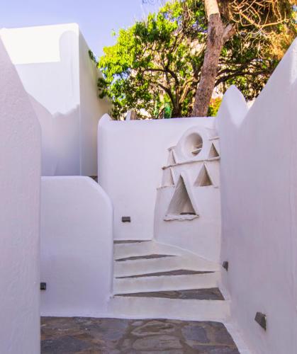 a staircase leading up to a white wall with a stair case at Zisis Pension in Agios Stefanos
