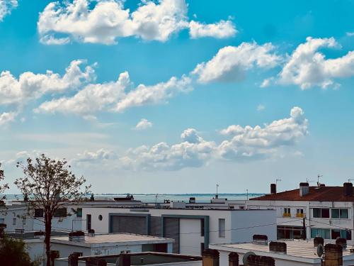 une vue sur les bâtiments et un ciel bleu avec des nuages dans l'établissement L'escapade du 3ème - Aperçu mer & Terrasse en Centre-ville, à Royan