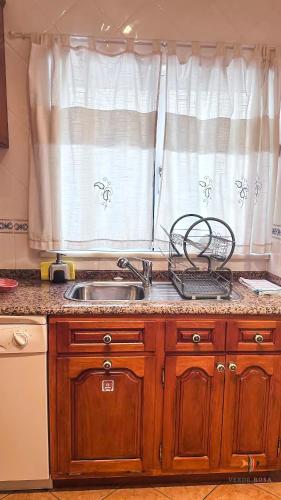 a kitchen counter with a sink and a window at Pátio Privado com Churrasqueira by Férias em Figueira in Figueira da Foz