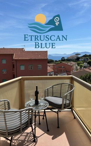 a patio with two chairs and a table with a bottle of wine at Etruscan Blue House in Piombino