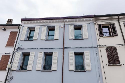 a building with white windows and shutters on it at La casa di rovere in Lugo
