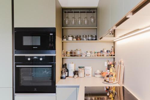 a kitchen with a black microwave and a stove at La casa di rovere in Lugo