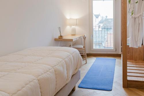 a bedroom with a bed and a desk and a window at La casa di rovere in Lugo
