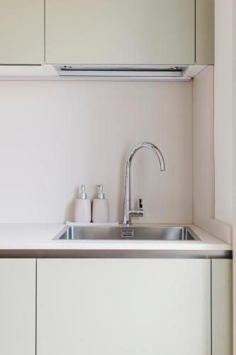 a kitchen with a sink in a white kitchen at La casa di rovere in Lugo