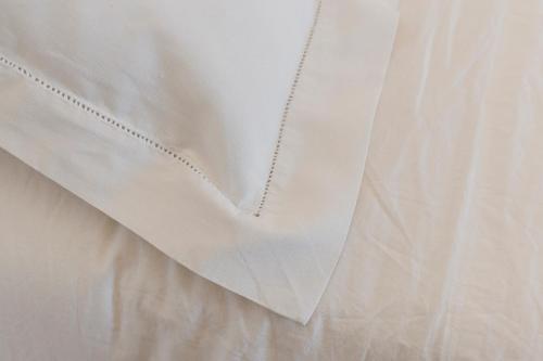 a white shirt with a chain on a bed at La casa di rovere in Lugo