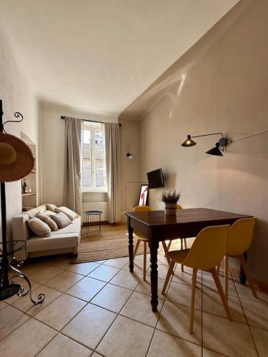 a living room with a table and a couch at BALCONCINI VISTA TORRI - comfort nel centro storico in Savigliano