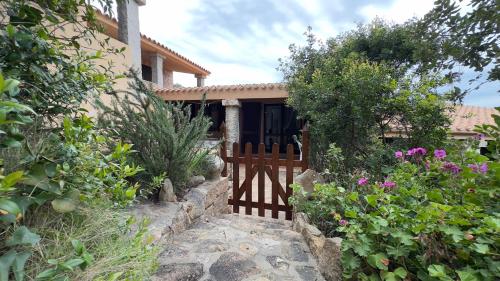 a wooden gate in front of a house with flowers at Casa Azul villa e piscina relax Costa Paradiso Sardegna in Costa Paradiso