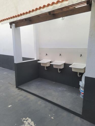 ein Badezimmer mit drei Waschbecken und einer Waschbeckenreihe in der Unterkunft KITNETES Bot in Angra dos Reis
