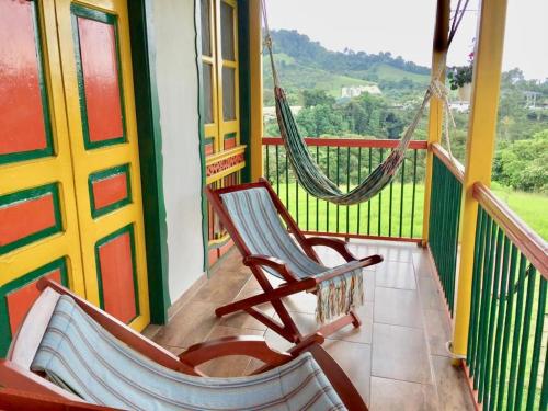 a rocking chair on a balcony with a hammock at Mamatina Hotel in Santa Rosa de Cabal