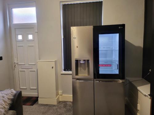 a refrigerator in a room with a window and a door at 30mins from Alton Towers - Panama Apartments Lodge in Stoke on Trent