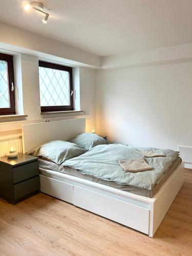 a bedroom with a large white bed and two windows at New Studio, Central & Quiet in Munich