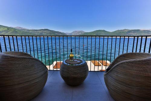 a balcony with a table and two chairs looking out at the water at Casa Brilla in Tivat