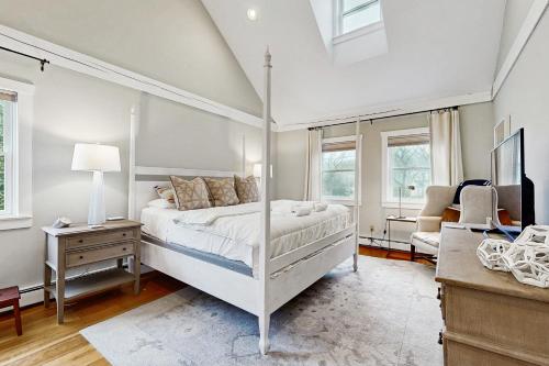 a bedroom with a canopy bed and a desk at #OB Pool House in Oak Bluffs