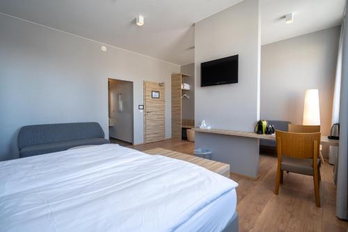 a bedroom with a bed and a desk with a television at Hótel Laugarbakki in Laugarbakki