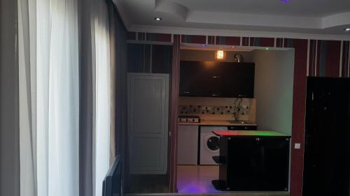 una stanza con cucina, televisione e porta di Apartment SOFI a Tbilisi City